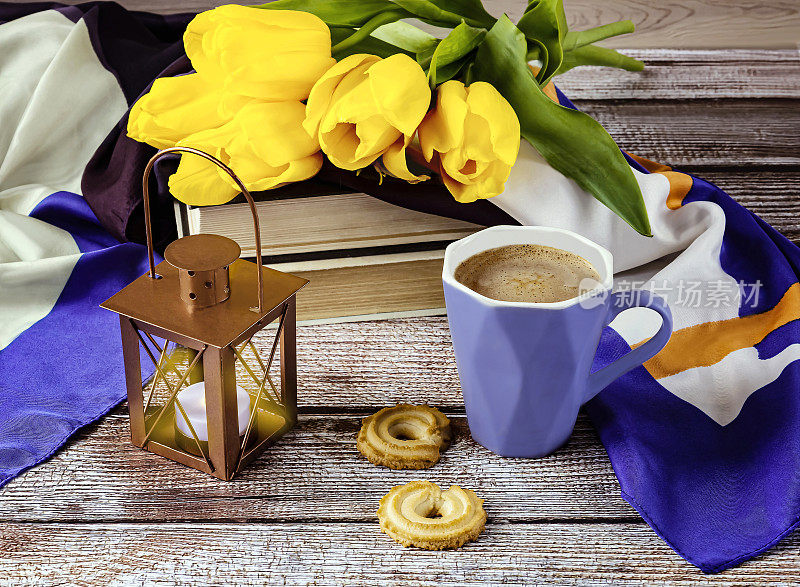 Yellow tulips and a blue cup of coffee.